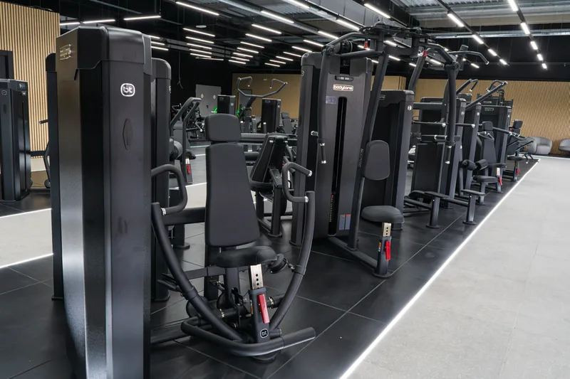 A row of selectorised Bodytone strength machines along a training floor.